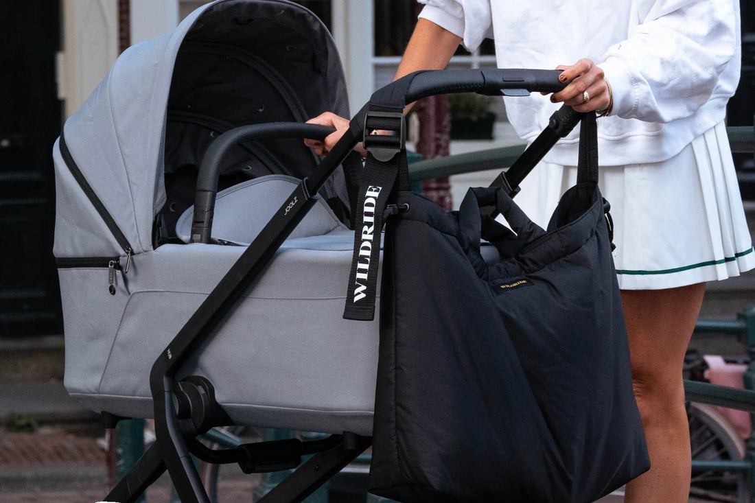 Borsa nera appesa al passeggino durante una passeggiata con il neonato
