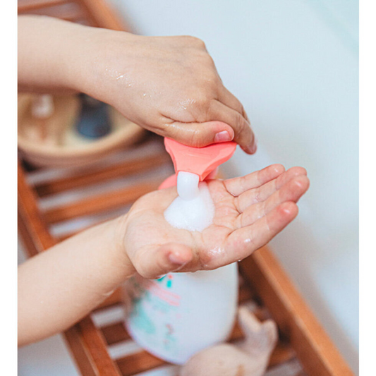 mousse detergente per bambini bianca e arancio usata da un bambino e fa la schiuma