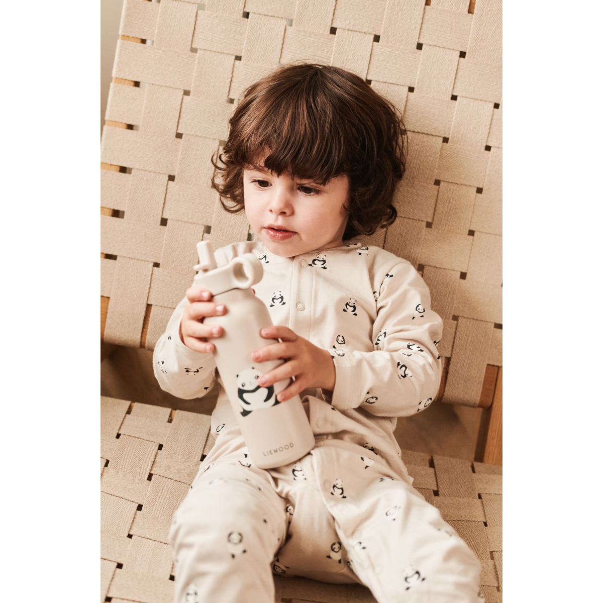 Bambino che utilizza la borraccia Liewood con panda e tutina in cotone biologico coordinata