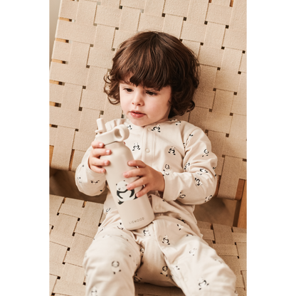 Bambino che utilizza la borraccia Liewood con panda e tutina in cotone biologico coordinata